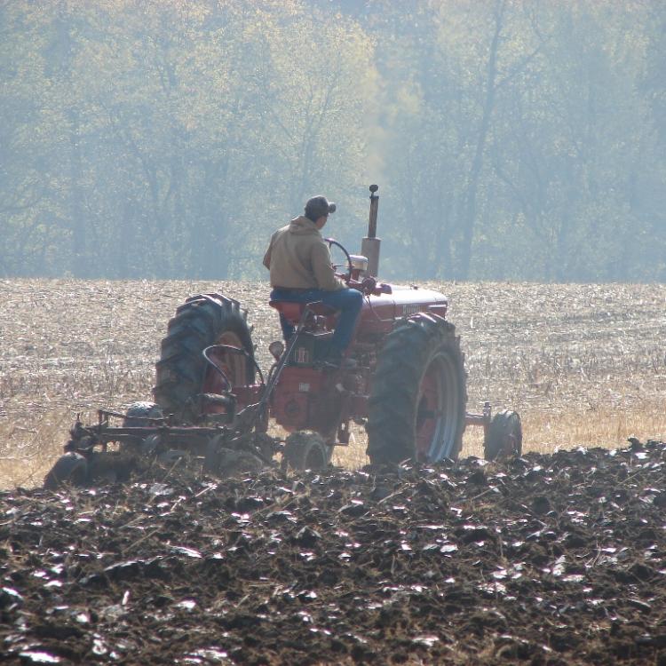  man on tractor plowing field